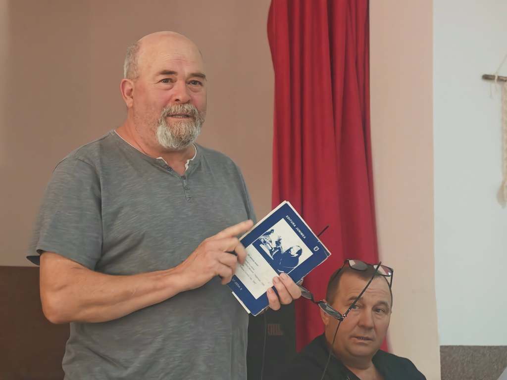 Poetul Mihai Apostu prezentând unul dintre volumele sale la întâlnirea culturală din Dodești.